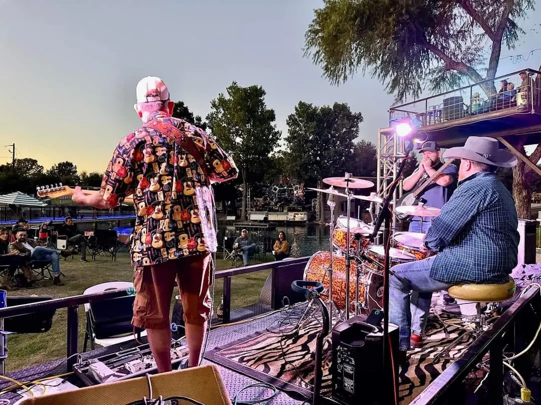 Clay Potter Band performing at sunset while a crowd watches from the lawn Clay Potter Band performing at sunset while a crowd watches from the lawn