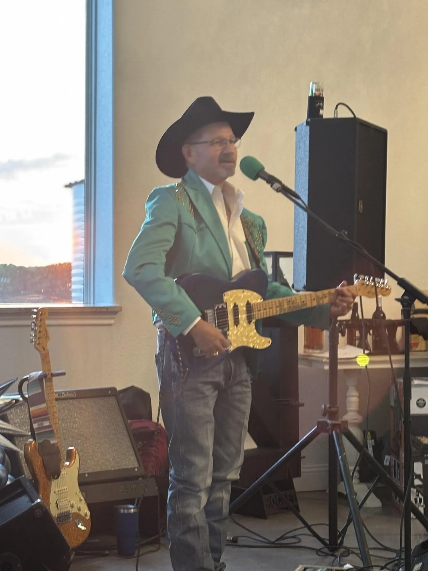 Clay Potter Band guitarist in a cowboy hat and teal western jacket singing and playing electric guitar Clay Potter Band guitarist in a cowboy hat and teal western jacket singing and playing electric guitar