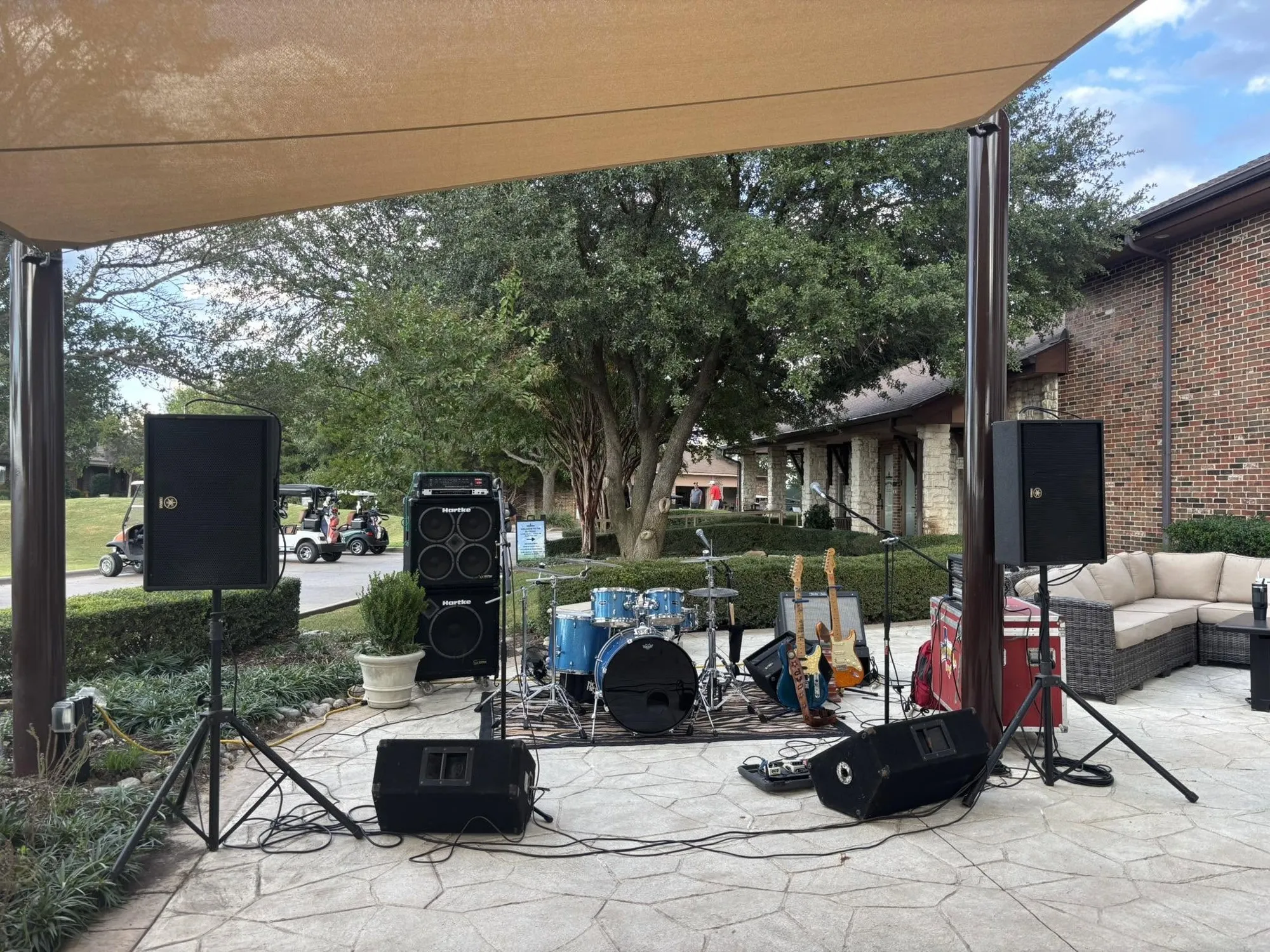 Clay Potter Band drums, guitars, and sound system set up on a shaded stone patio for an outdoor private event Clay Potter Band drums, guitars, and sound system set up on a shaded stone patio for an outdoor private event